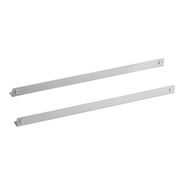 A pair of metal brackets for pans with white rectangular objects on the ends.