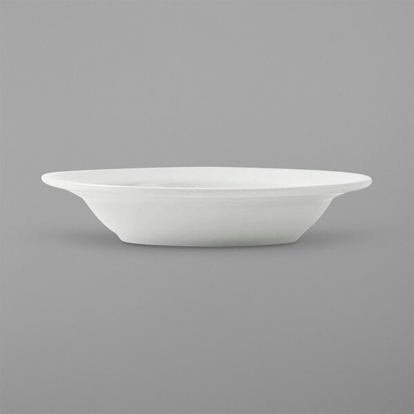 A close up of a Tuxton Alaska narrow rim fruit bowl on a white surface.