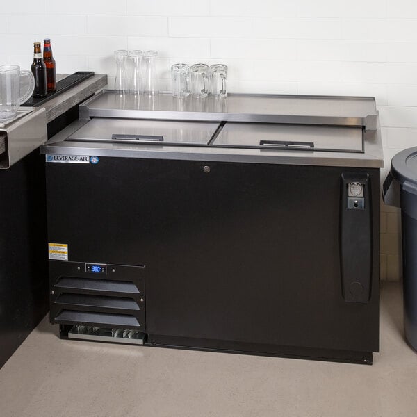 A black Beverage-Air Frosty Brew deep well bottle cooler on a counter in a brewery tasting room.