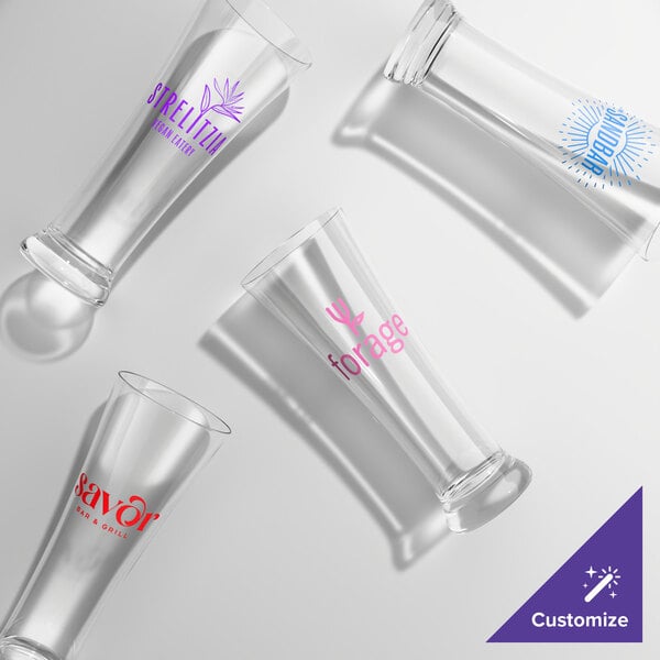 A set of four clear, customizable pilsner glasses with different colored logos and text printed on each.