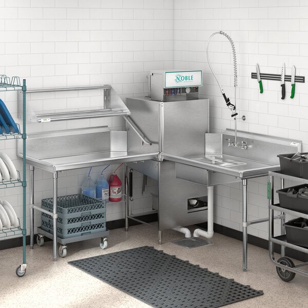 A professional kitchen with a Regency stainless steel dishtable on the right with a sink and shelf.