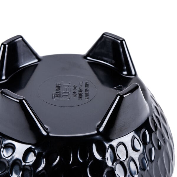 A black melamine bowl with holes in it.