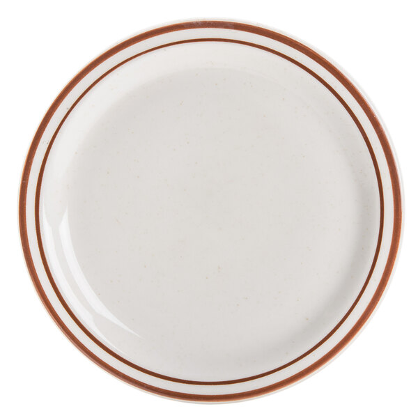 A close up of a Libbey narrow rim stoneware plate with brown stripes on it.