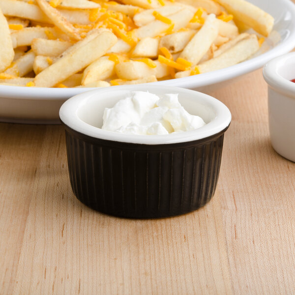 a bowl of french fries with a bowl of cream cheese