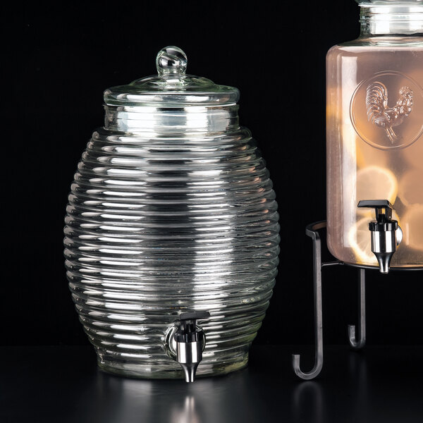 A Libbey beehive glass beverage dispenser with a metal stand.