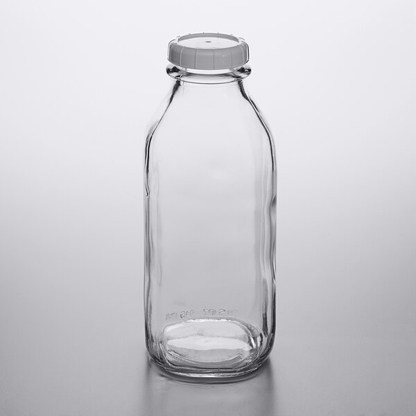 A clear glass Libbey milk bottle with a white lid.
