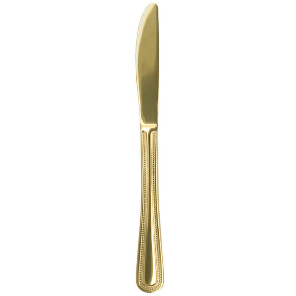 A Walco Colgate gold stainless steel dinner knife with a long blade.