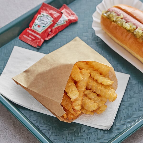 A tray with a Carnival King large Kraft French fry bag filled with fries and a hot dog on it.