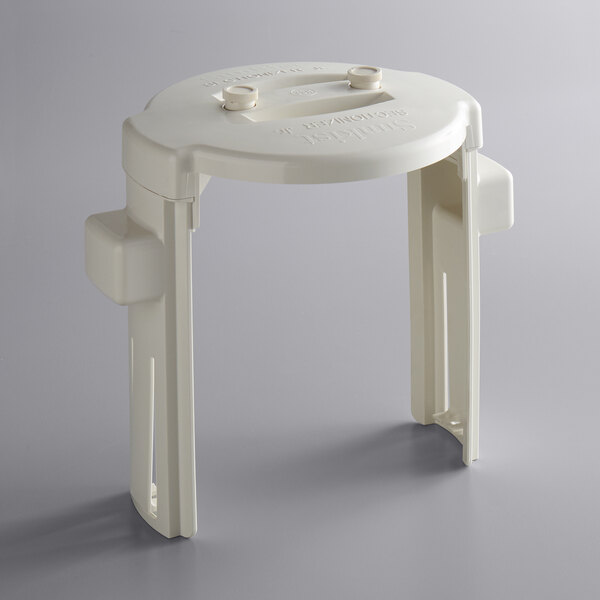 A white plastic circular plunger with two legs.