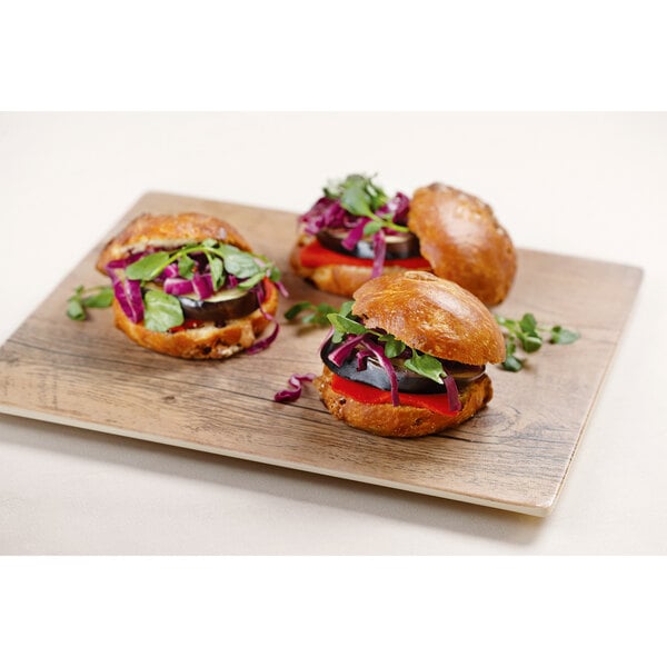 A group of burgers on a faux wood square display board.