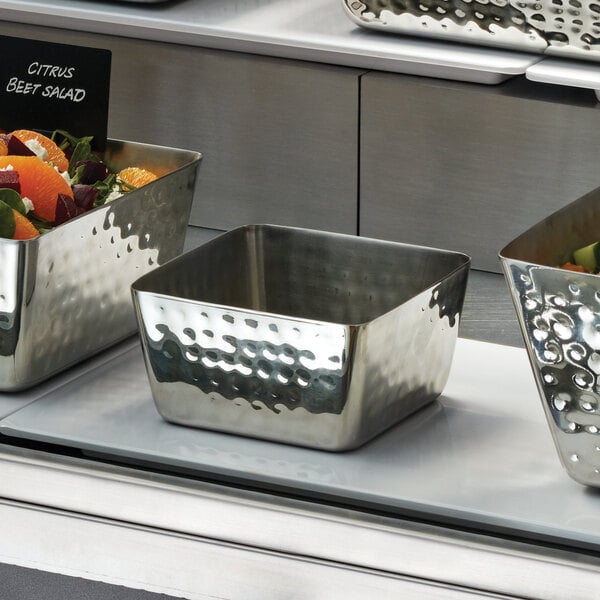 A close-up of an American Metalcraft Hammered Stainless Steel square bowl.