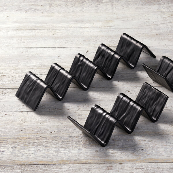 An American Metalcraft black faux-slate melamine taco holder with 4 or 5 compartments on a wood surface.