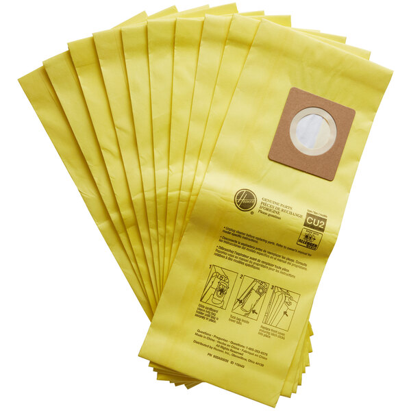 A group of yellow Hoover vacuum bags with a hole in the middle.