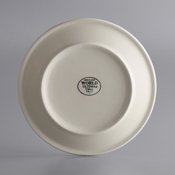 A close-up of a white Libbey narrow rim stoneware plate with black text on it.