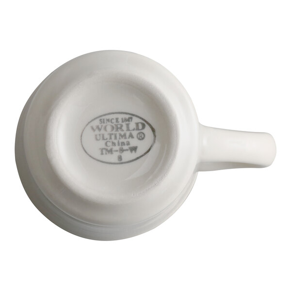 A white stoneware mug with a handle, shown upside down to display the manufacturer's mark on the bottom.