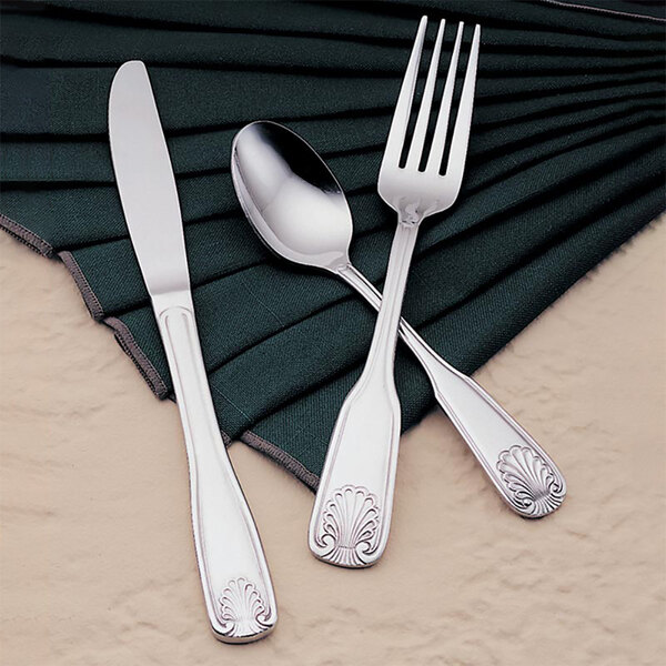 A Libbey stainless steel bouillon spoon placed on a napkin.