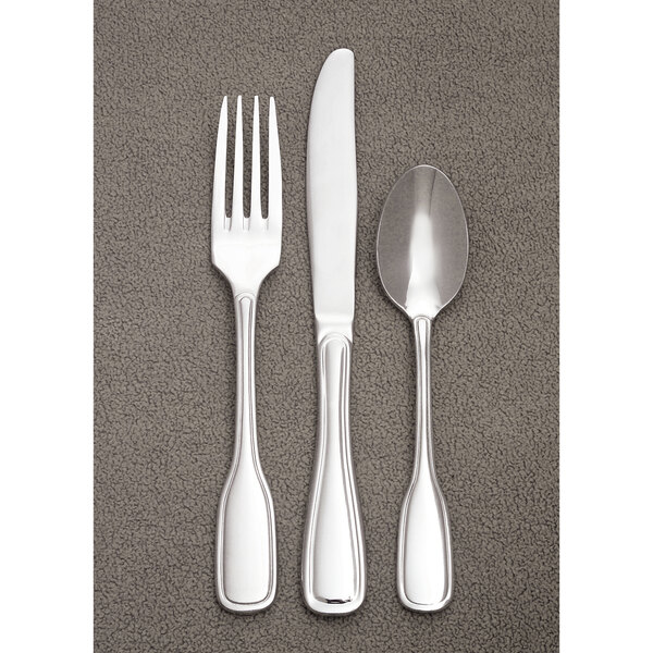 A close-up of a Libbey stainless steel European dinner knife on a grey surface.