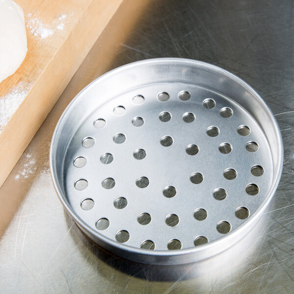 An American Metalcraft aluminum pizza pan with holes in it.