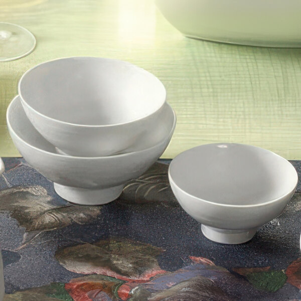 A group of CAC Sushia white porcelain rice bowls on a table.