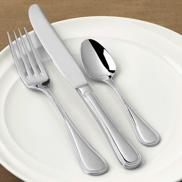 A white plate with a Libbey stainless steel medium weight tablespoon on it.
