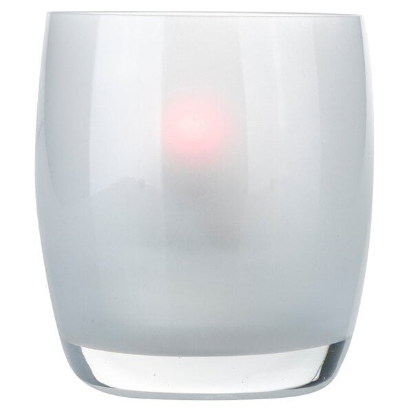 A close up of a white glass vase with a red light inside.