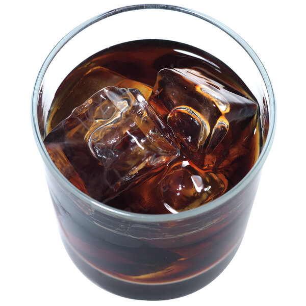 A glass of brown liquid with Manitowoc regular size ice cubes in it.