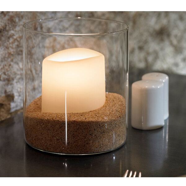 A Sterno Allure candle in a glass container on a table.