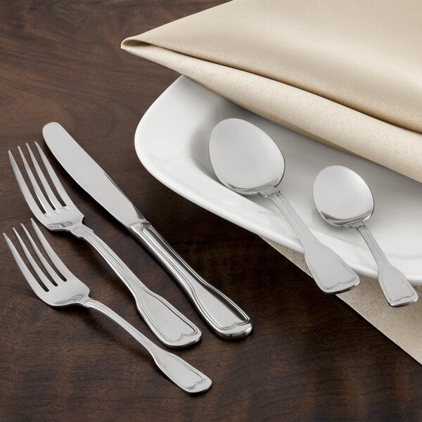 A Walco stainless steel iced tea spoon on a white plate.