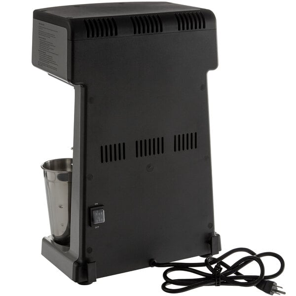 A black Waring drink mixer with metal cups on a counter.