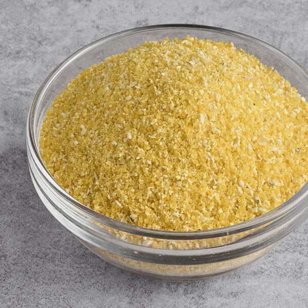 A clear glass bowl filled with yellow organic corn grits or polenta.