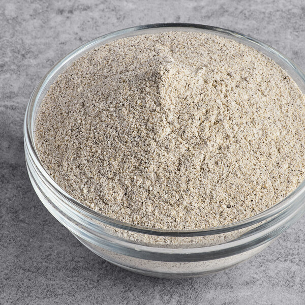 A glass bowl filled with finely ground organic whole grain buckwheat flour.