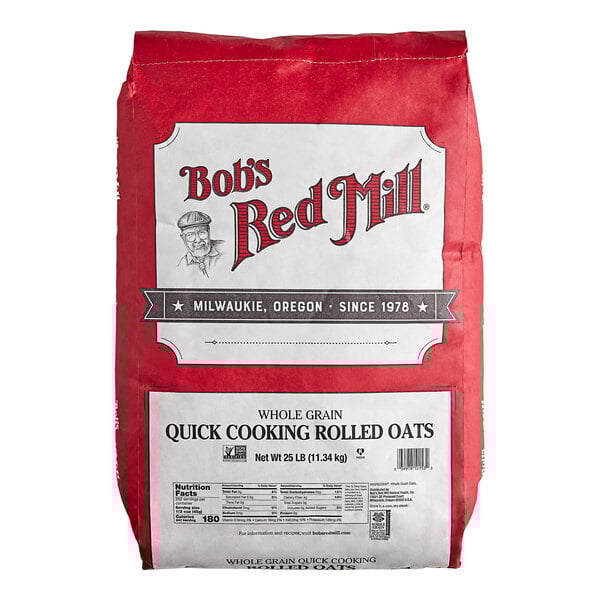 A large red and white bag of Bob's Red Mill quick-cooking whole grain rolled oats weighing 25 pounds.