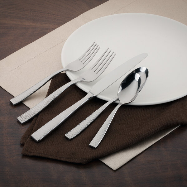 A white plate with a Walco stainless steel European dinner fork on it.