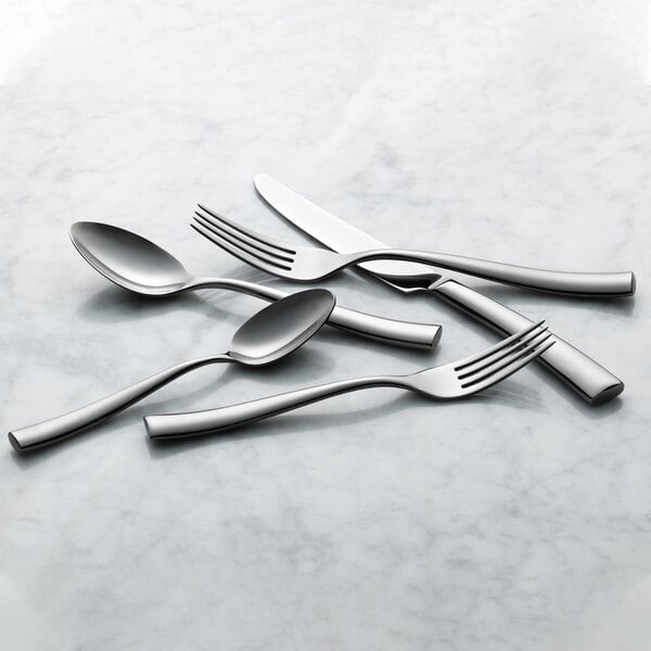 The handle of a Reserve by Libbey stainless steel dinner fork on a marble surface.