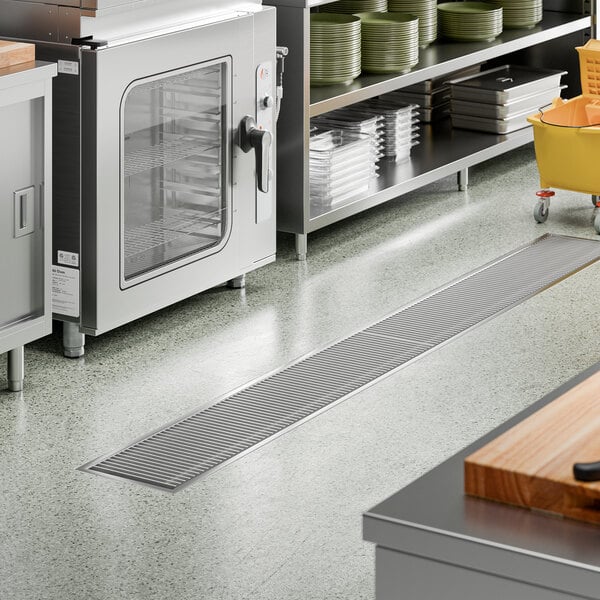 A 12 inch by 108 inch stainless steel floor trough with a grate, designed for commercial kitchen drainage.
