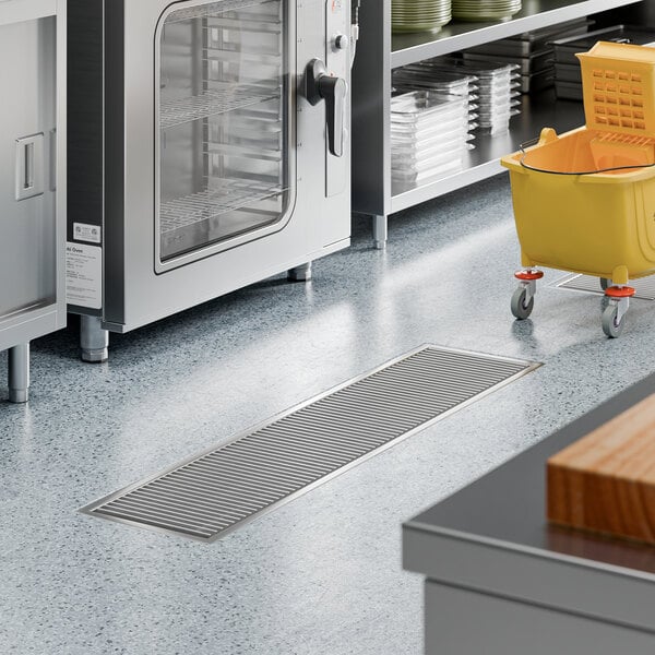A 12-inch by 54-inch stainless steel floor trough with a grate, designed for commercial kitchen drainage.