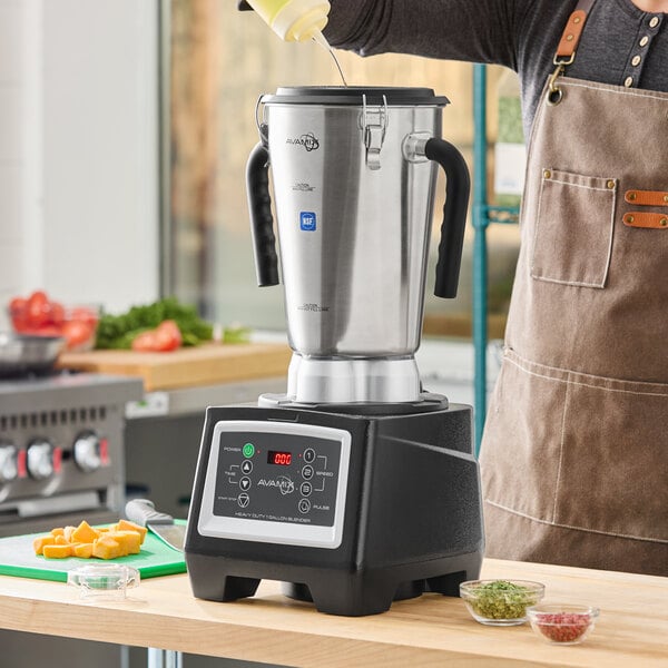 A large stainless steel commercial food blender with a digital control panel and side handles, placed on a kitchen counter.