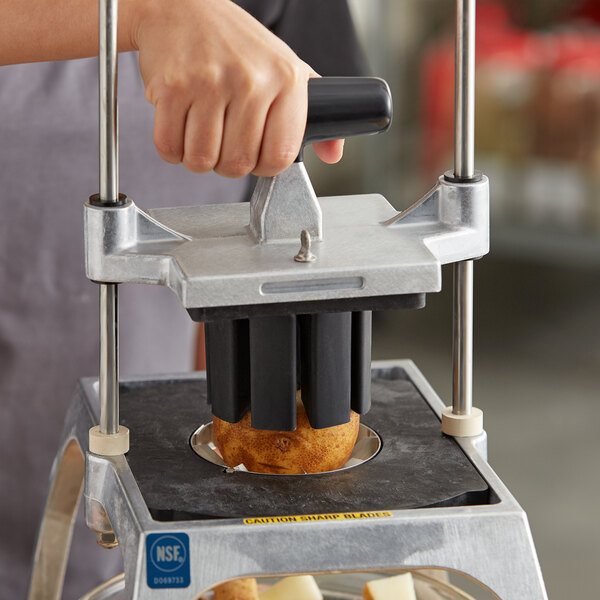 A hand using a Vollrath 8 section corer assembly to core a potato.