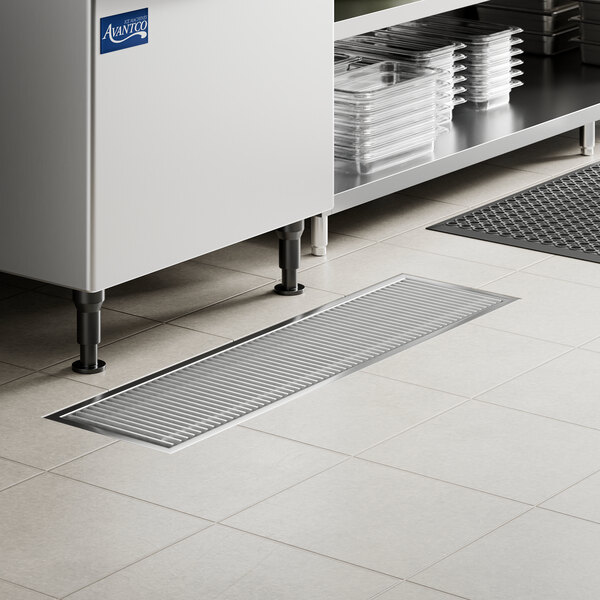A 12 inch by 48 inch stainless steel floor water receptacle with a grate, designed for commercial kitchen use.