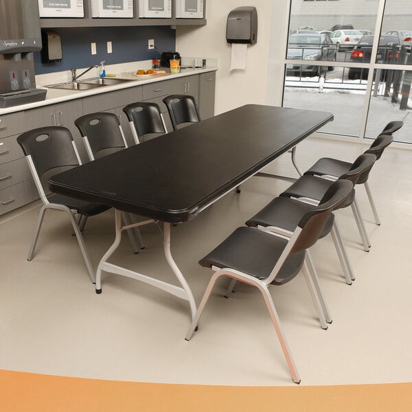 A black Lifetime plastic folding table set with white chairs