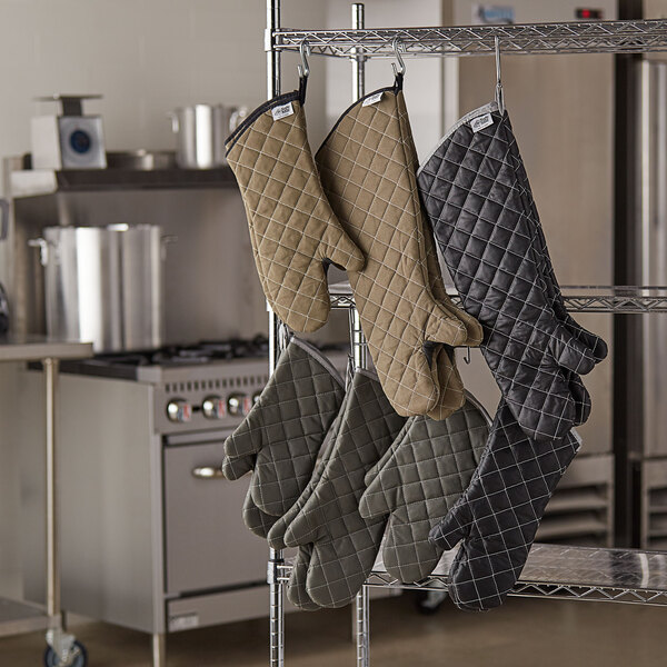 A rack with SafeMitt flame retardant oven mitts hanging on it.
