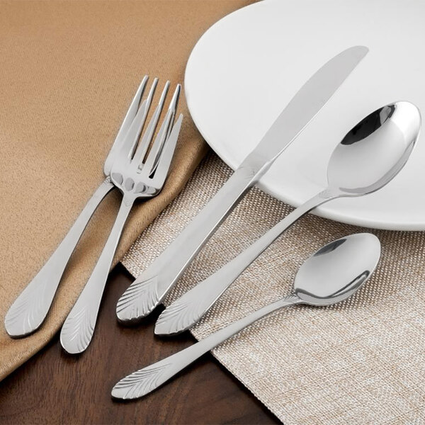 A plate with Walco Showboat salad forks and silverware.