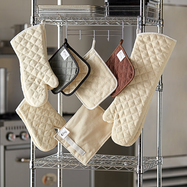 A rack with SafeMitt terry cloth pot holders hanging on it.