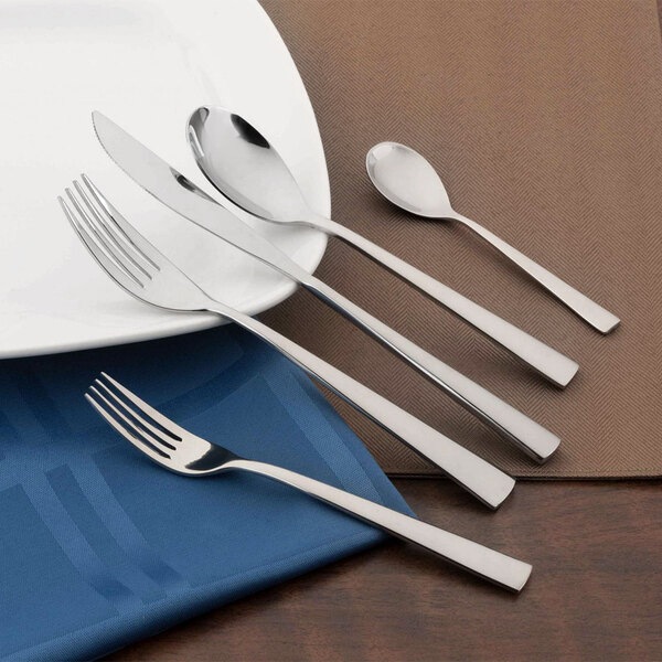 A white plate with a Walco Audition stainless steel teaspoon on it.