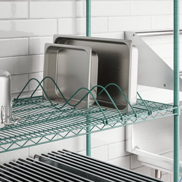 A metal shelf with a Regency Add-On Drying Rack holding metal trays.