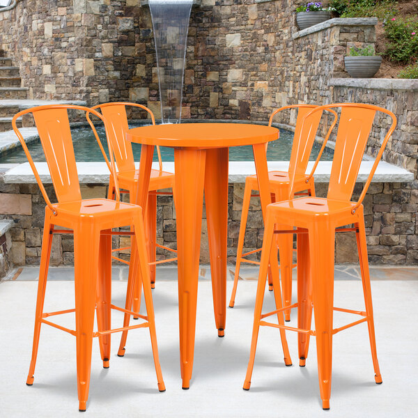 An orange metal bar table and chairs on an outdoor patio.