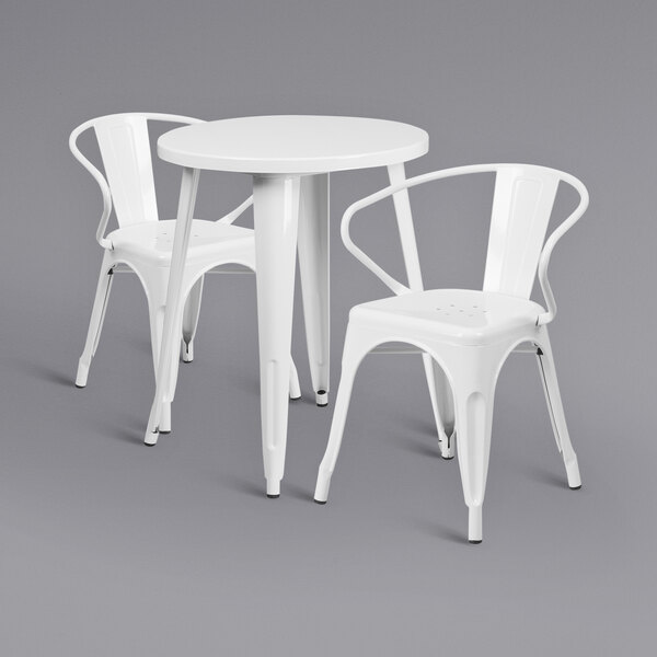 A white metal table with two white chairs.