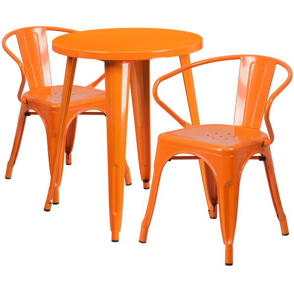 An orange metal table with two orange chairs.