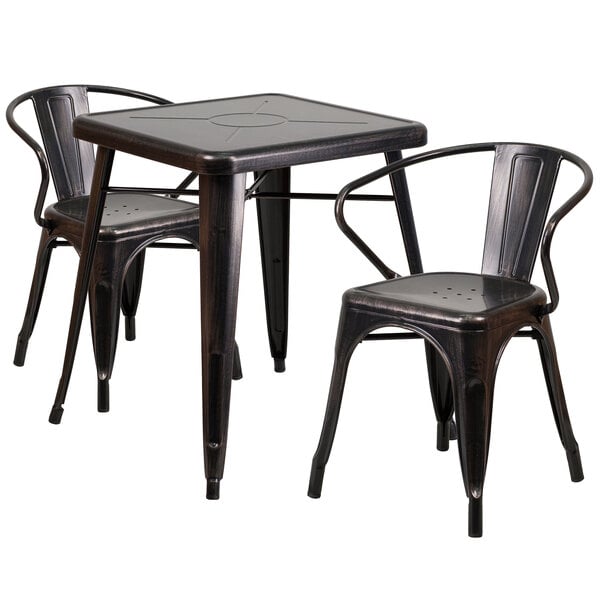 A black metal Flash Furniture table with a black square top and a circle in the middle with two black metal chairs with armrests.