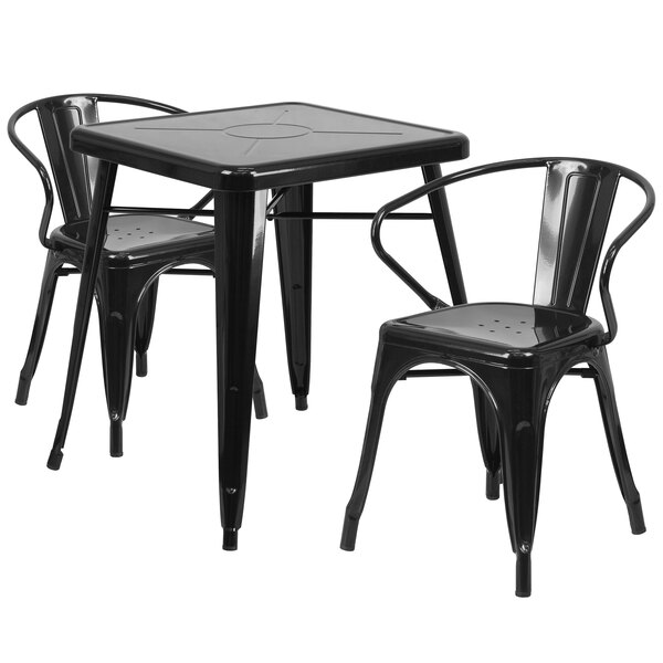 A black metal square bistro table with two matching chairs with armrests.